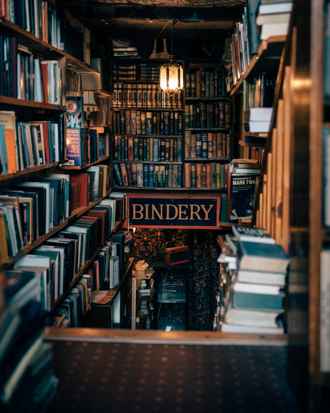 Stacks of old books line narrow aisles of a vintage bookstore.